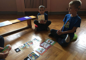 dwóch chłopców układa piktogramy z zasadami przedszkolnymi