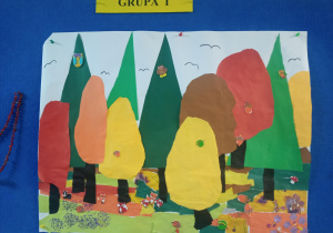 praca plastyczna na dużym kartonie, przedstawia las w jesiennych barwach. Praca wykonana z kolorowego papieru