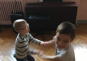 Dwóch chłopców tańczy.