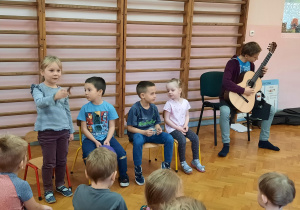 Uczeń wykonuje utwór na gitarze, a dziewczynka prezentuje galop konika z wykorzystaniem konika.