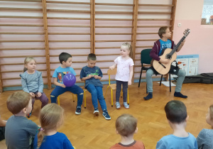 Uczeń wykonuje utwór na gitarze, a dziewczynka prezentuje falowanie morza z wykorzystaniem muszelki.