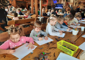 Dzieci rysują list do Świętego Mikołaja.