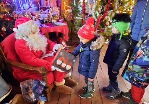 Chłopiec częstuje się cukierkiem od Świętego Mikołaja.