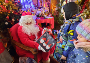 Chłopiec częstuje się cukierkiem od Świętego Mikołaja.