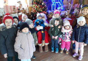 Dzieci z grupy III pozują do zdjęcia ze Świętym Mikołajem.