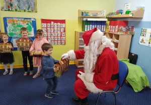 Mikołaj rozdaje prezenty dzieciom