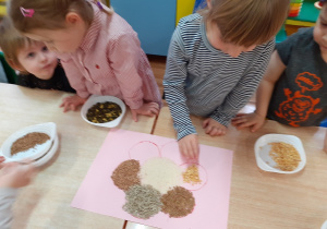 dzieci wykonują mandalę z nasion