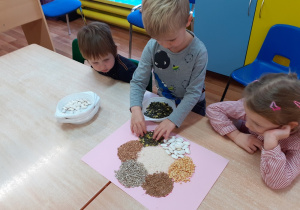 dzieci wykonują mandalę z nasion