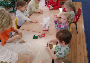 dzieci przy stoliku wykonują świąteczne pierniki