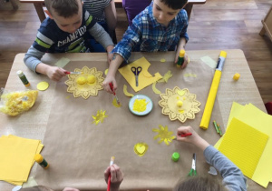 Dzieci z grupy żółtej przyklejają i malują słońca.