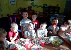 Dzieci przy stolikach świętują urodziny.