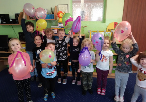 grupa dzieci trzyma w rękach kolorowe balony