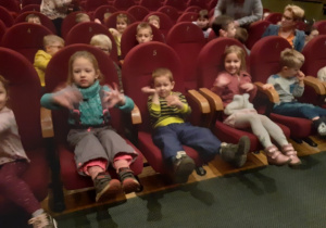 dzieci siedzą na widowni teatru