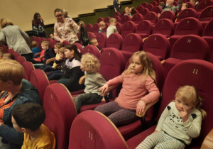 Dzieci siedzą na widowni teatru.