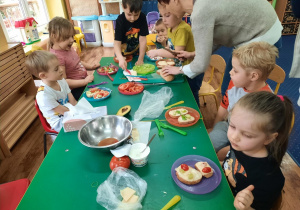 Dzieci przygotowują kanapki dla siebie.