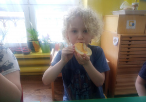 chłopiec zjada kanapkę