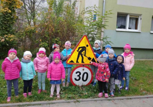 Dzieci na tle znaków drogowych.