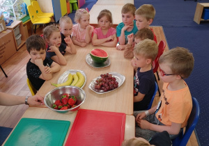 dzieci wykonują szaszłyki z owoców