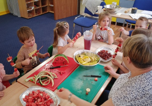 dzieci wykonują szaszłyki z owoców