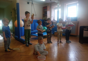 dzieci na sali gimnastycznej grają na instrumentach