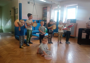 dzieci na sali gimnastycznej grają na instrumentach
